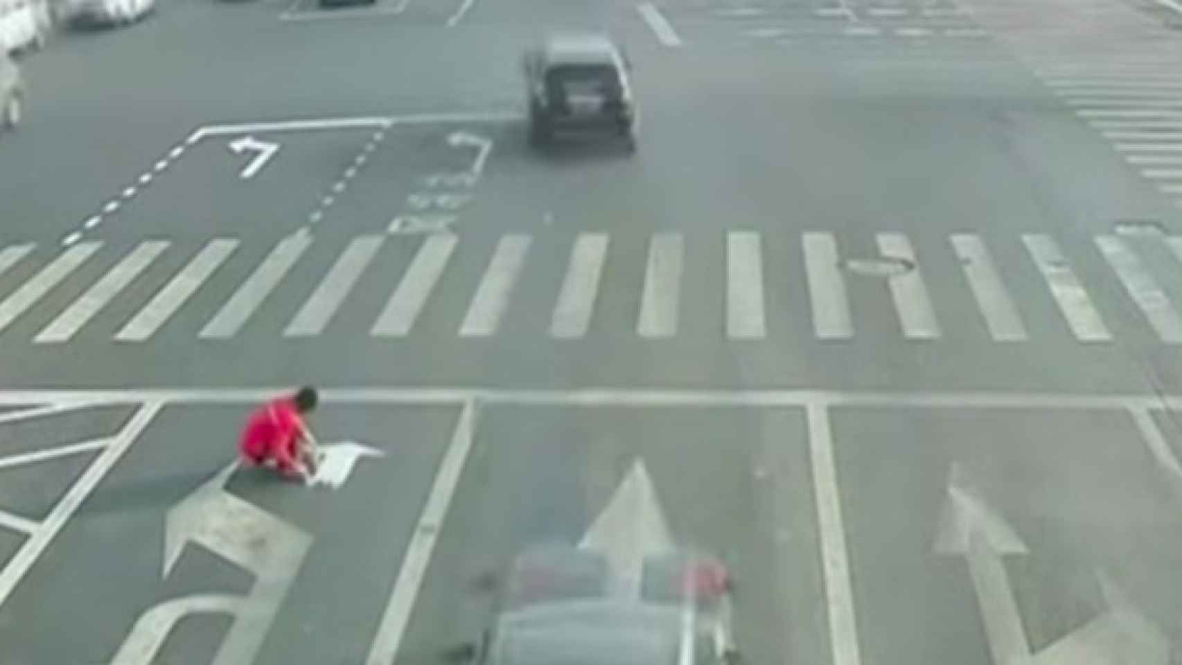 Un hombre chino pinta sus propias señales de tráfico sobre la calzada / CG
