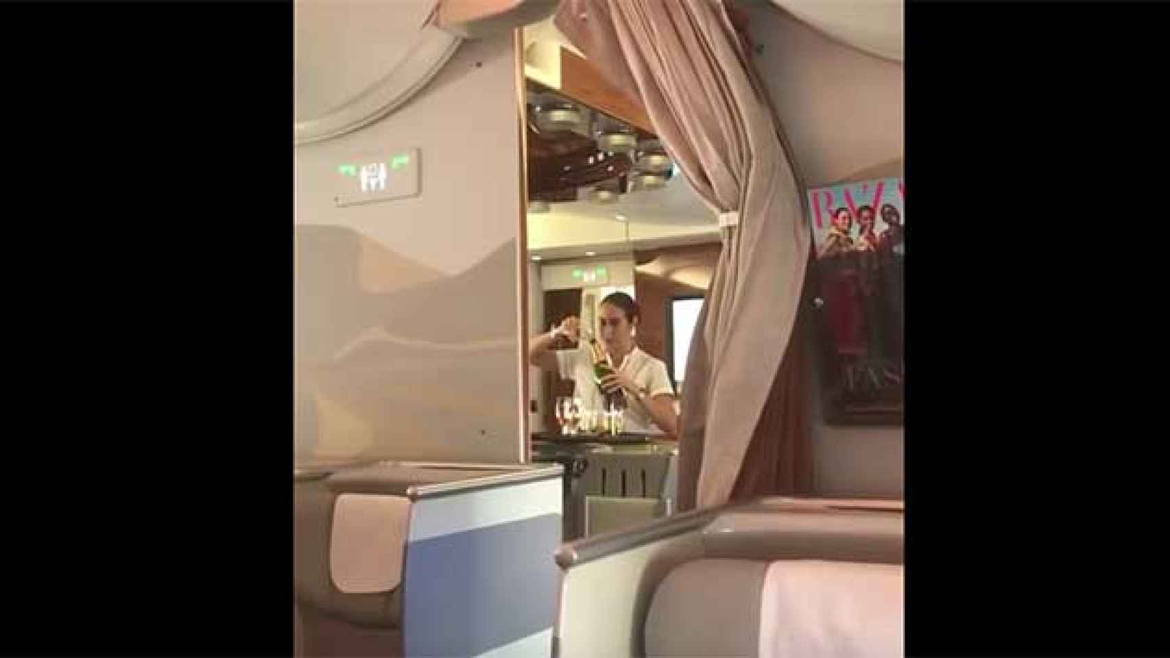 La azafata de Fly Emirates mientras rellena una botella de champán / CG