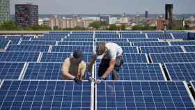 Trabajadores instalando paneles solares en un edificio para generar energías renovables / EFE