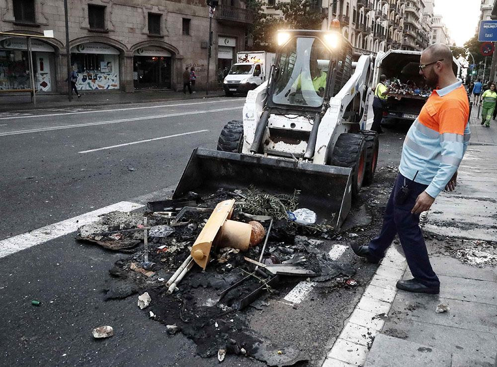 Aspecto que presentan las calles de Barcelona con restos de contenedores quemados tras los incidentes registrados anoche en los enfrentamientos / EFE