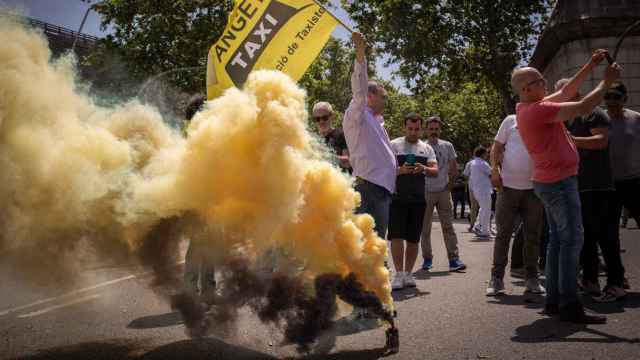 Un taxista prende un bote de humo en la protesta de esta mañana en Barcelona a las puertas del Parc de la Ciutadella / DAVID ZORRAKINO - EUROPA PRESS