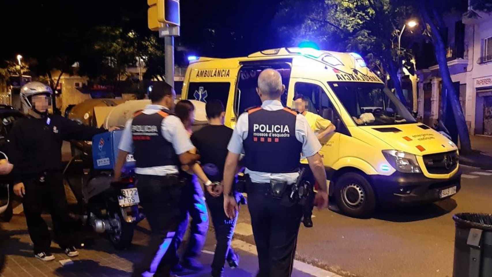 Los Mossos d'Esquadra trasladan a un hombre que se ha atrincherado con un cuchillo en una pizzería de la calle Sicilia de Barcelona / CG