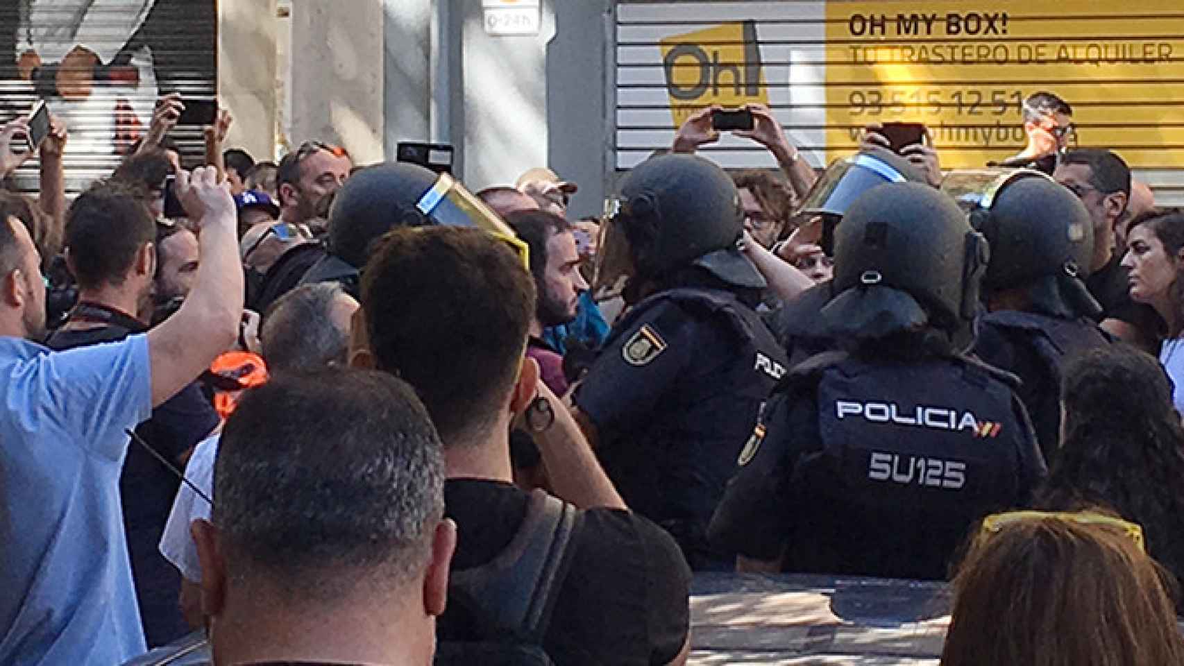 Agentes de la Policía Nacional, rodeados a pocos metros de la sede de la CUP, en la calle Casp de Barcelona, el 20 de septiembre de 2017 / CG