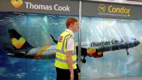 Un operario de un aeropuerto junto a un mostrador de Thomas Cook / EFE