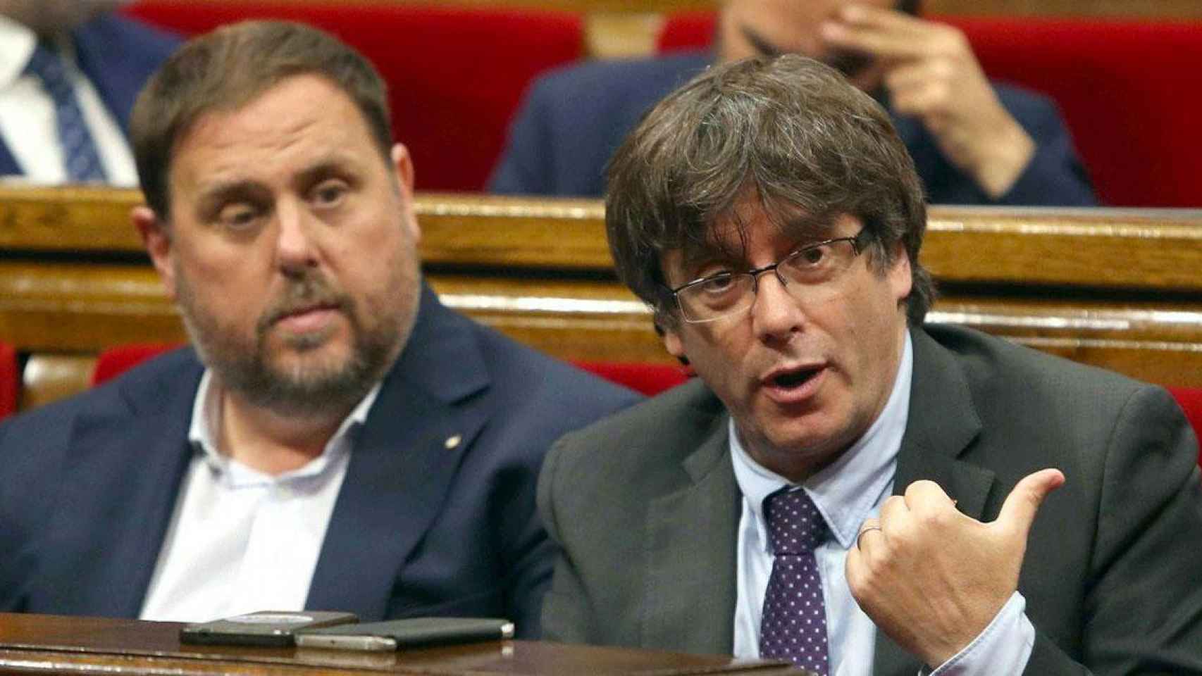Carles Puigdemont (d) y Oriol Junqueras (i) en el Parlament de Cataluña / EFE