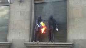 Dos encapuchados, quemando una bandera española en la manifestación del 1 de mayo en Barcelona