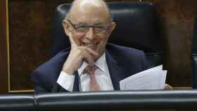 Cristóbal Montoro rie en el Congreso mientras interviene un diputado de la oposición.