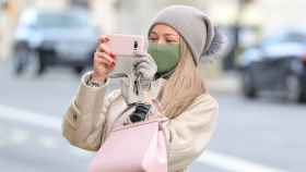 Una mujer con mascarilla haciendo una foto con su smartphone / EP