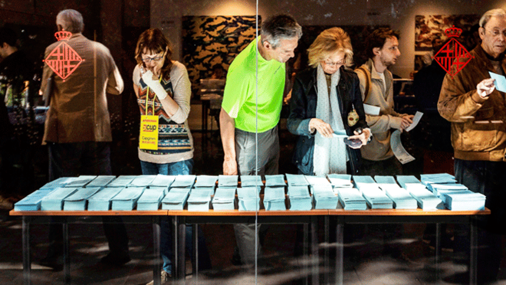 Votantes y apoderados miran papeletas en el Centre Cívic Pere Pruna de Barcelona / EFE