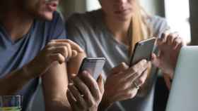 Un hombre y una mujer usan sus teléfonos móviles para acceder a las redes sociales / EP