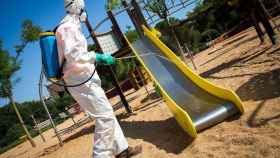 Un hombre limpia y desinfecta de coronavirus un parque infantil de Barcelona / EP