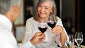 Una pareja de cierta edad brinda con vino tinto
