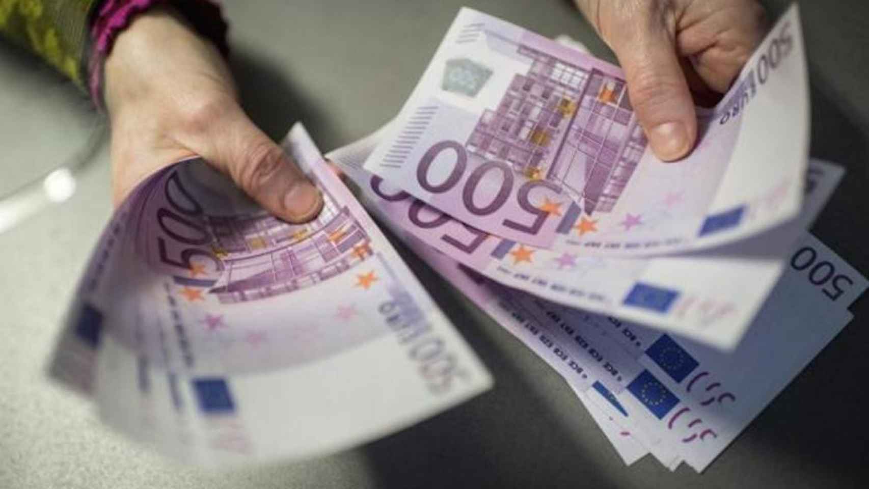 Un empleado muestra varios billetes de 500 euros / EFE