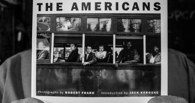 Un hombre sostiene un ejemplar de 'The Americans'.