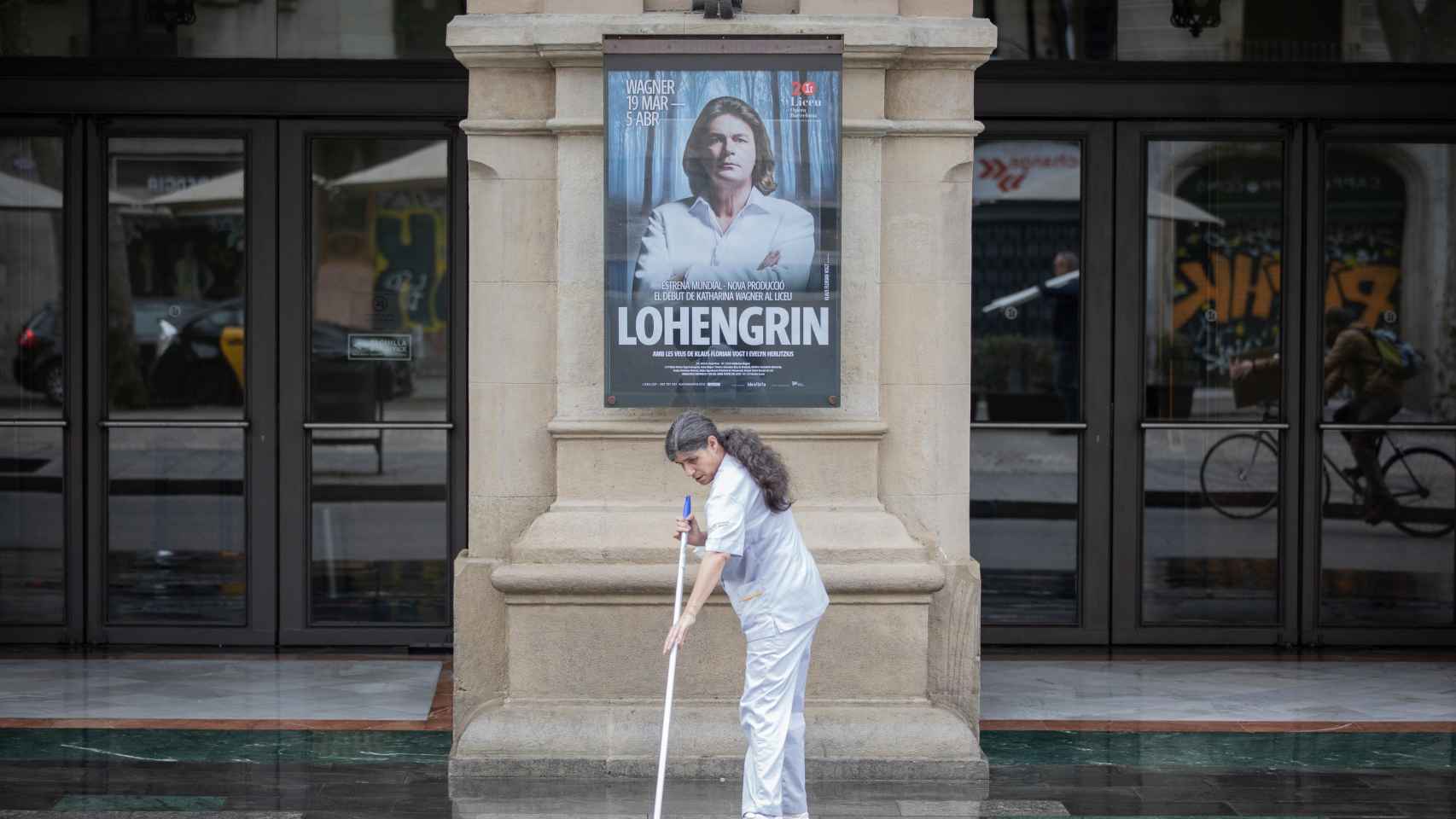 Una mujer limpia en la puerta del Gran Teatre del Liceu Barcelona durante el estado de alarma por coronavirus / EUROPA PRESS