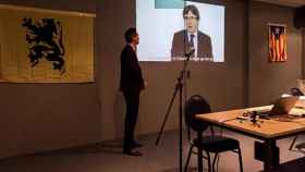 Imagen de la intervención telemática de Carles Puigdemont en el acto de Lovaina donde las cámaras captaron sus mensajes a Toni Comín / EFE