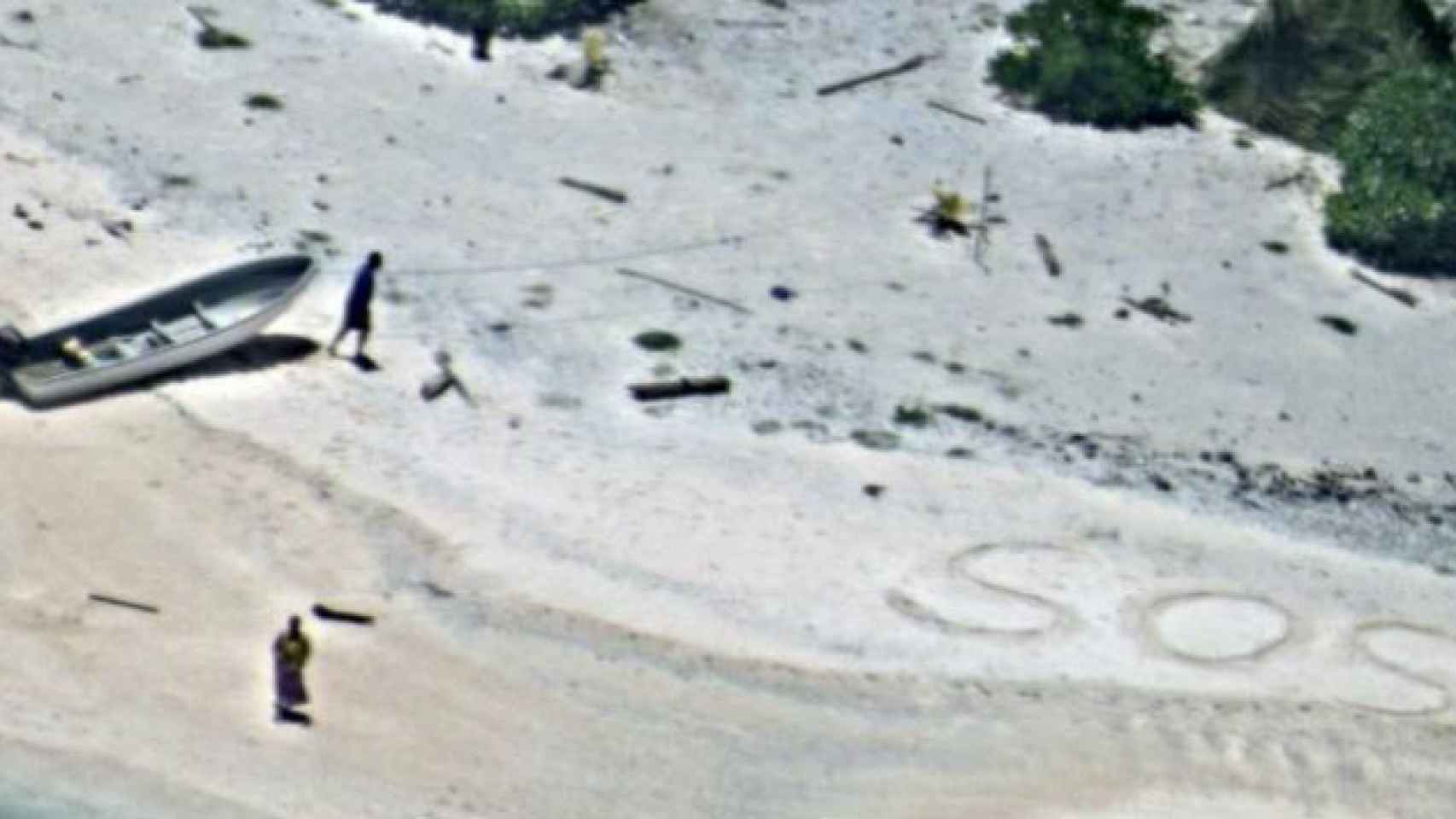 Linus y Sabina Jack junto al símbolo SOS que escribieron en la arena de East Fayu, la isla donde se quedaron atrapados en Micronesia. / TWITTER