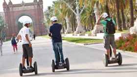Tres turistas circulando con un 'segway' en el paseo Lluís Companys de Barcelona / CG