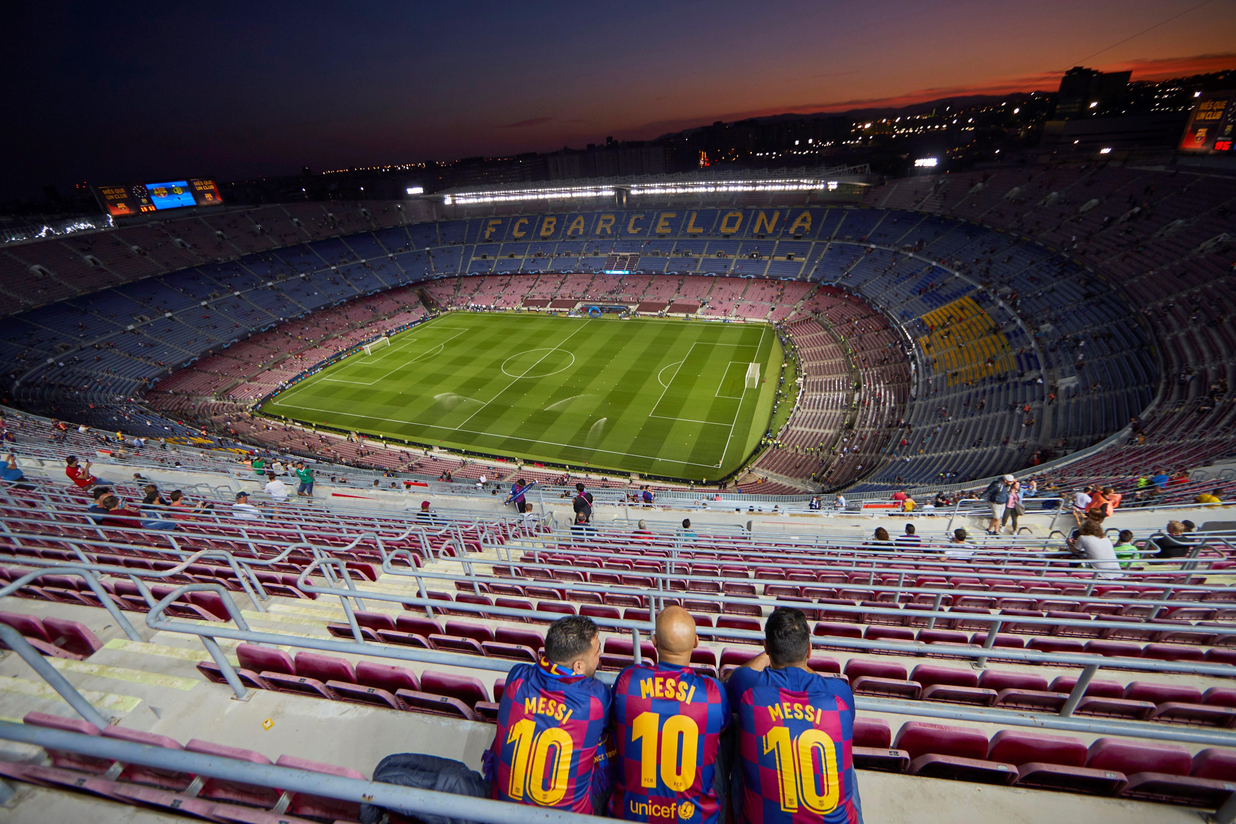 Una foto de tres aficionados del Barça en el Camp Nou / EFE