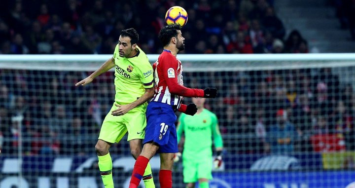 Sergio Busquets y Diego Costa pelean por un balón durante el Atlético-Barça / EFE