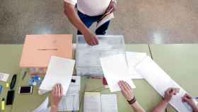 Un hombre deposita su voto en la urna este domingo en un colegio electoral de Valencia.