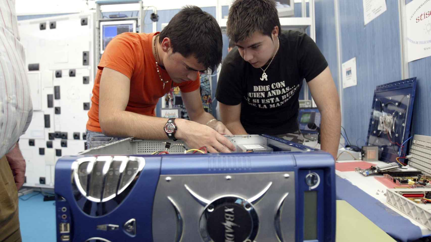 Dos jóvenes reparan un aparato en un curso de FP