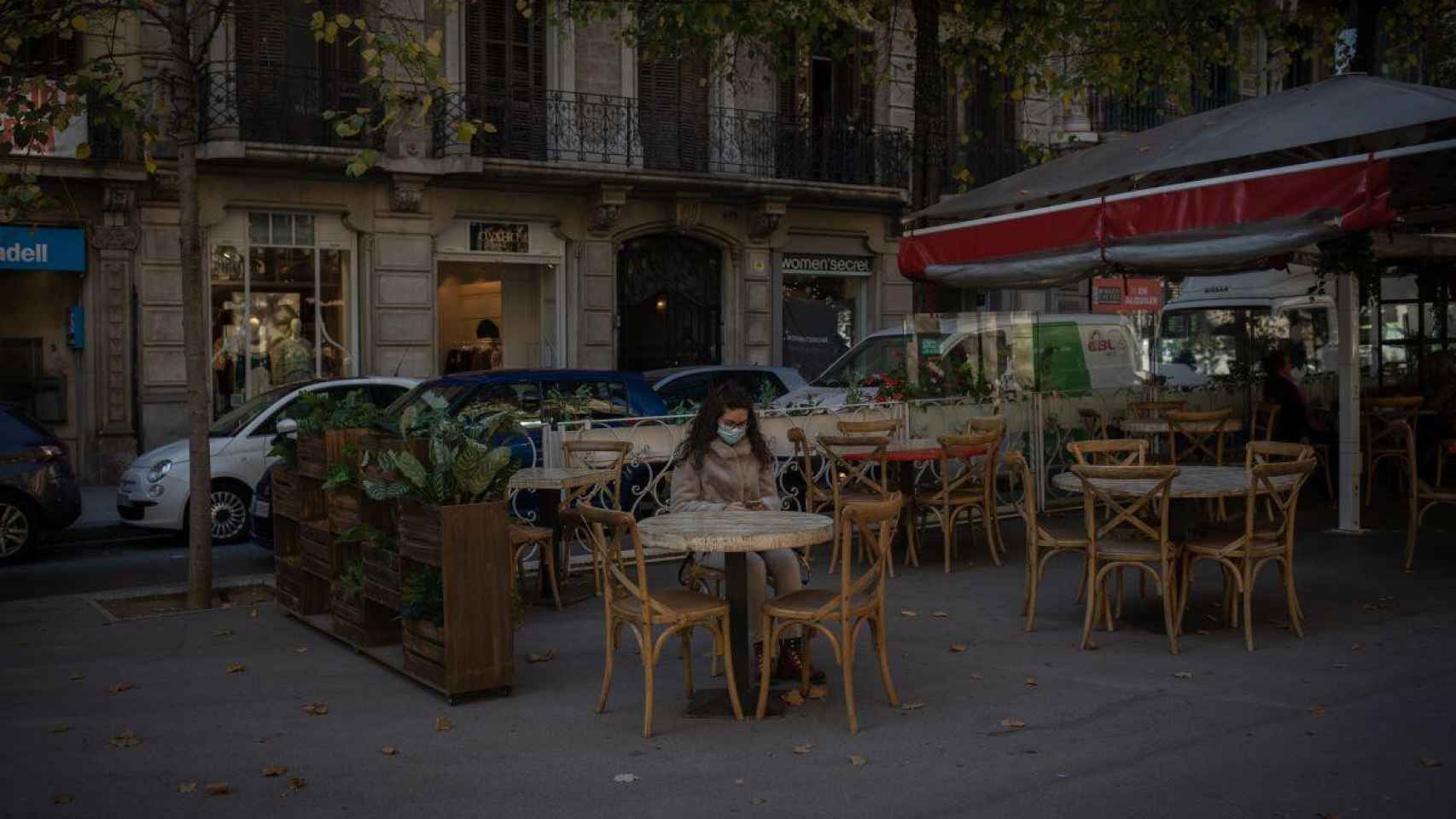 Una joven sentada en una terraza de Barcelona prácticamente vacía: el Gremio de la restauración pide ampliar horarios / EP