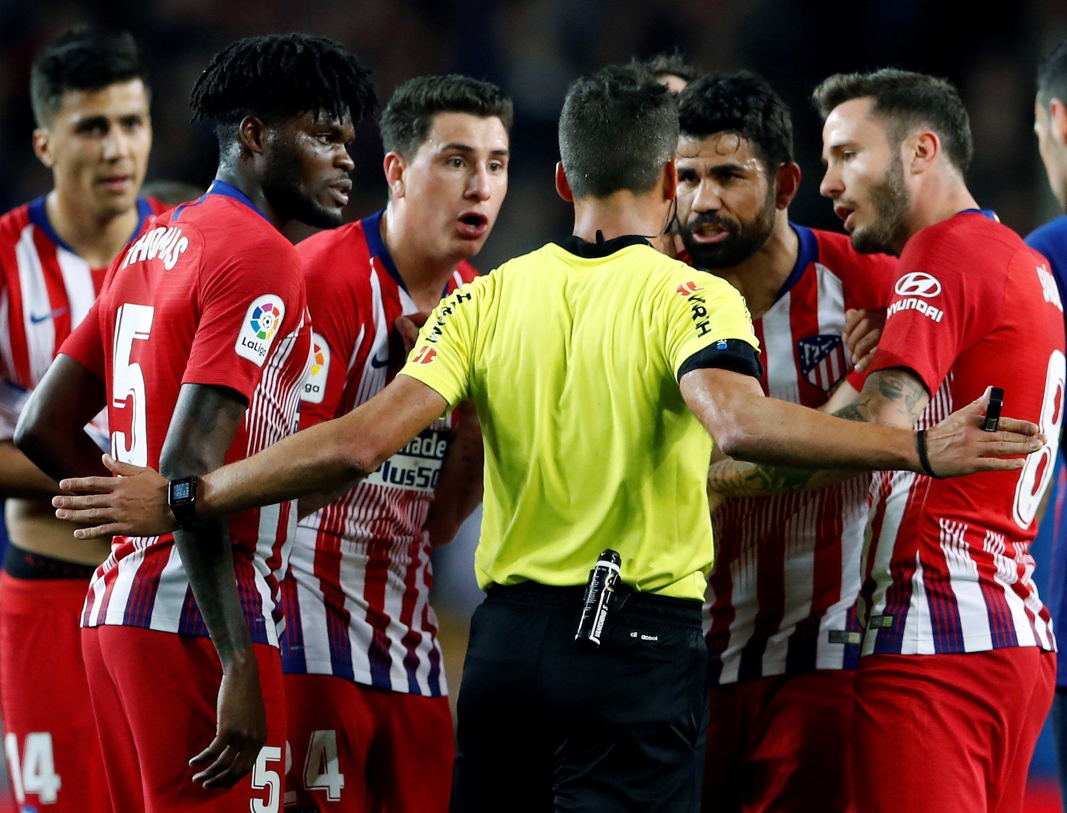 Una foto de los jugadores del Atlético de Madrid reclamando a Gil Manzano la expulsión de Diego Costa / EFE