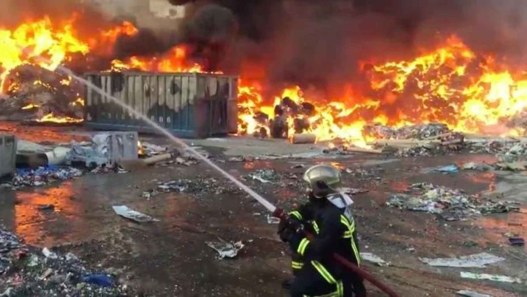 Un bombero tratando de apagar el incendio producido el exterior de una planta de reciclaje de papel en Arganda del Rey / TWITTER