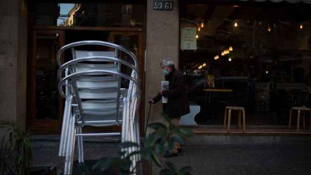 Un hombre pasa por delante de un restaurante con la terraza cerrada por las restricciones del Govern / EP