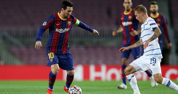 Leo Messi con el balón encarando un jugador rival