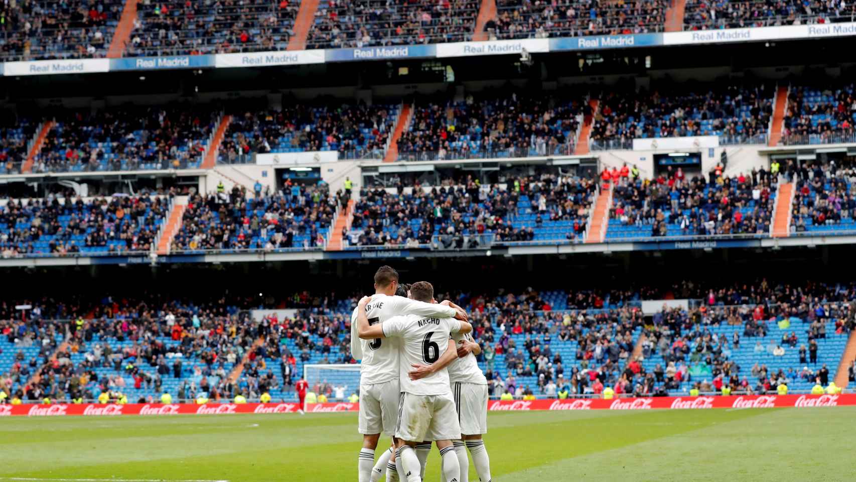 Los futbolistas del Real Madrid celebran un gol con la grada del Bernabéu semivacía / EFE