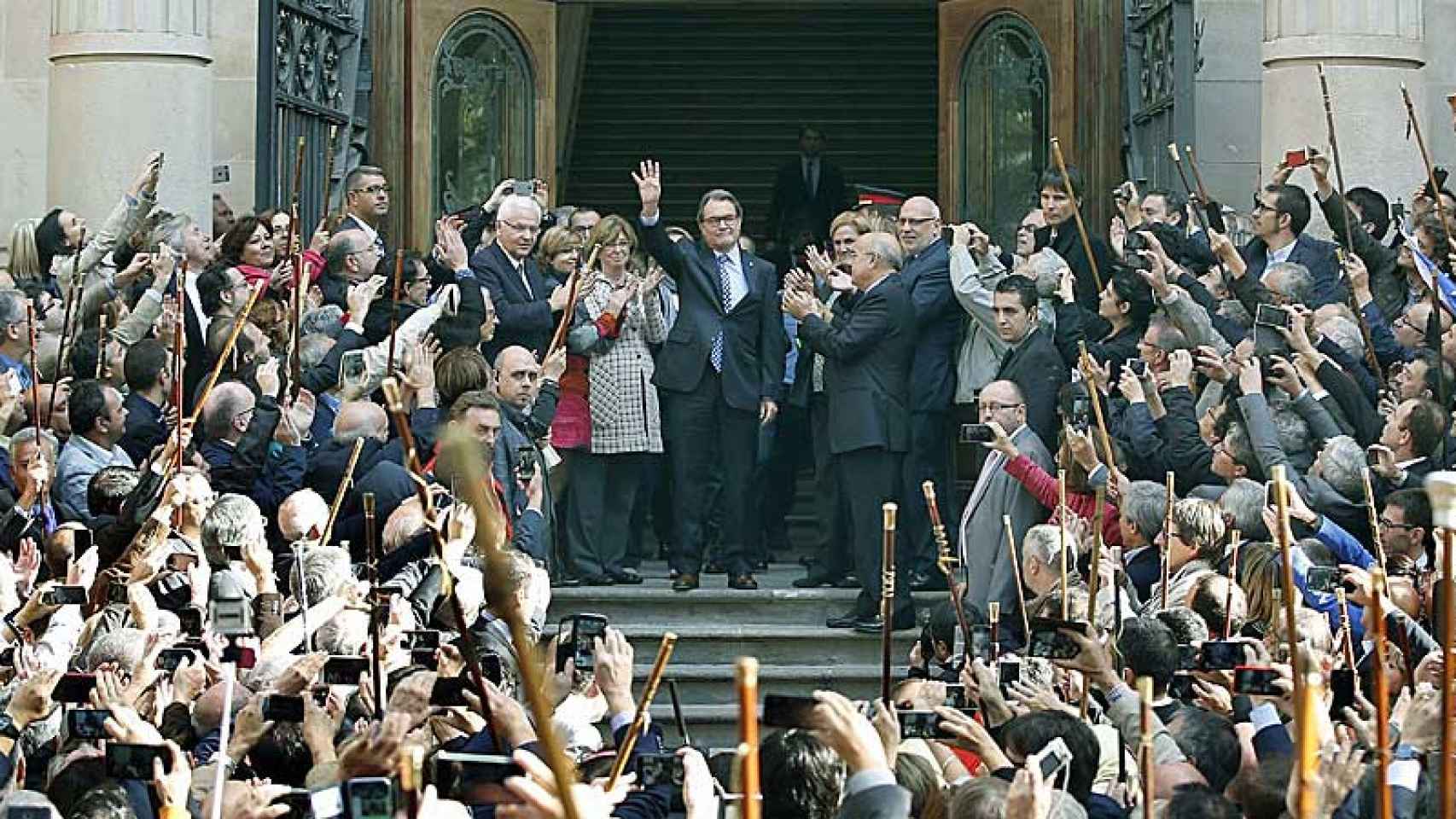 El presidente en funciones de la Generalitat, Artur Mas, saluda a los manifestantes reunidos para apoyarle tras declarar ante el TSJC imputado por organizar el 9N en contra de lo ordenado por el TC