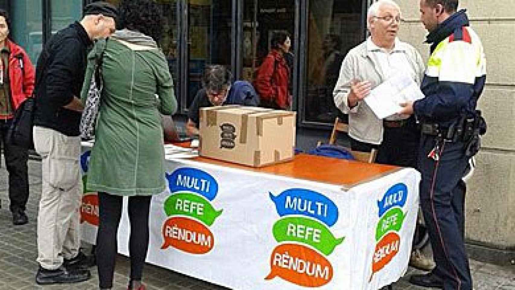 Un mosso d'esquadra insta a un organizador del Multirreferéndum a desmontar un punto de votación