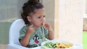 Una niña mientras come en una imagen de archivo / PXHERE