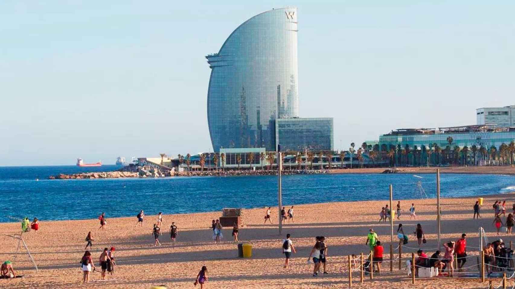 Imagen de una playa de Barcelona con el hotel W Barcelona en el horizonte / EFE