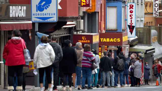 Personas haciendo cola para comprar tabaco en El Portús, una localidad en que una mitad está en España y la otra en Francia / EFE