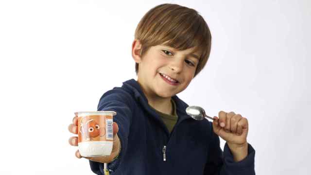 Un niño muestra un yogurt infantil de la marca Danone / DANONE