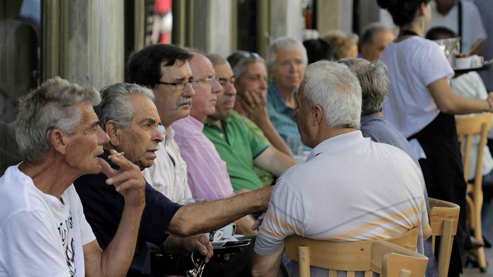 Un grupo de ancionados griegos conversaba en una calle de Atenas esta mañana