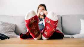 Una chica descansa en el sofá con su pijama navideño / PEXELS