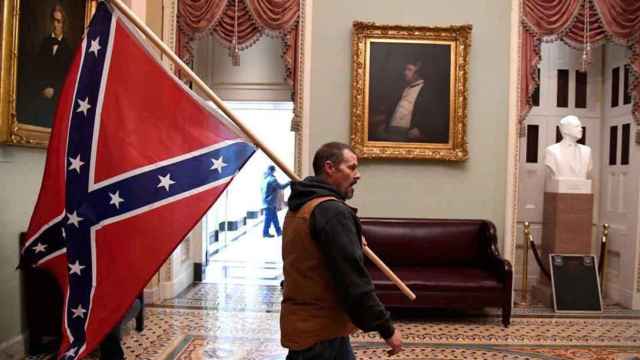 Uno de los asaltantes del Capitolio con la bandera confederada