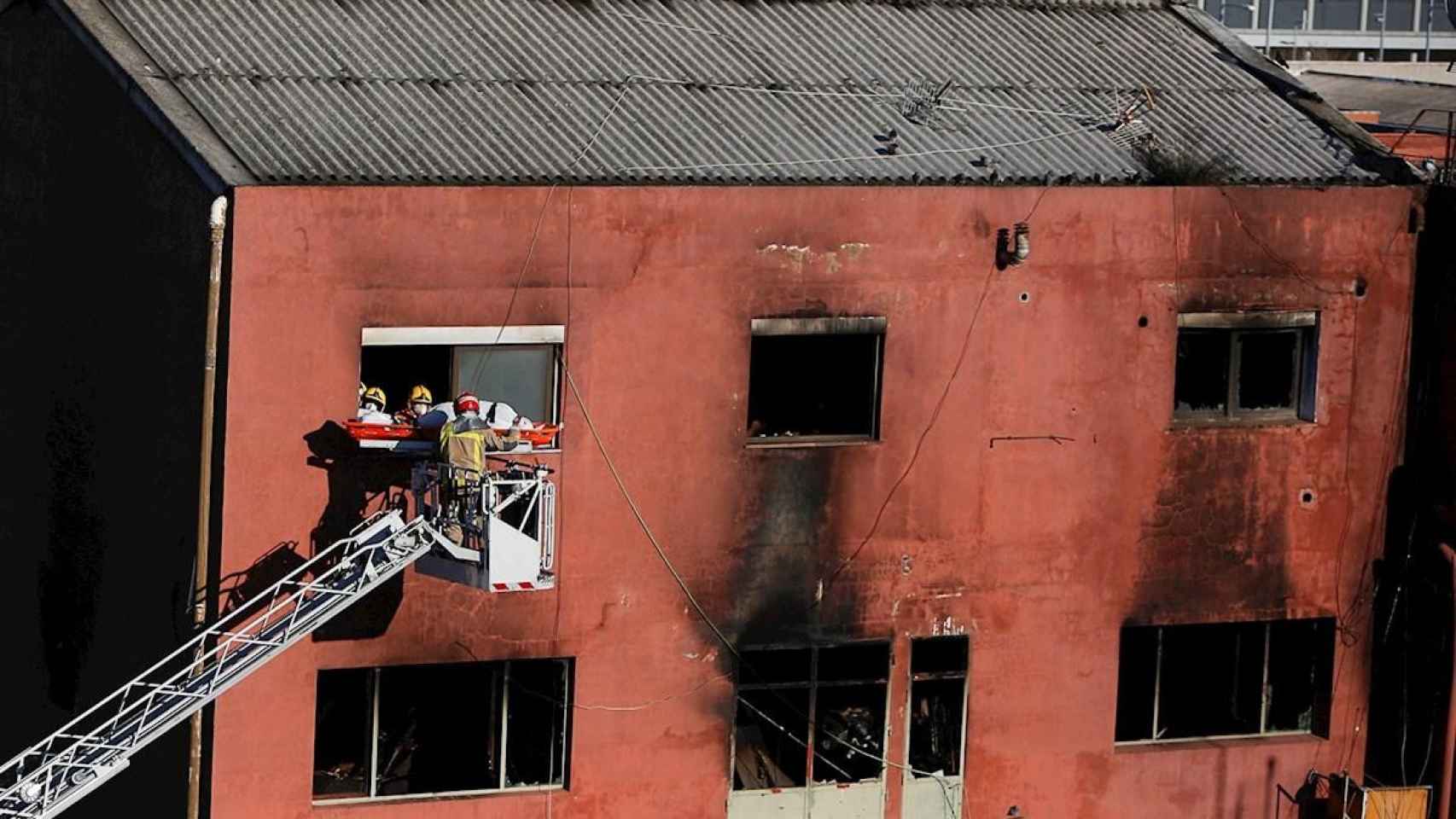 Bomberos trabajando en el edificio incendiado en Badalona / EFE