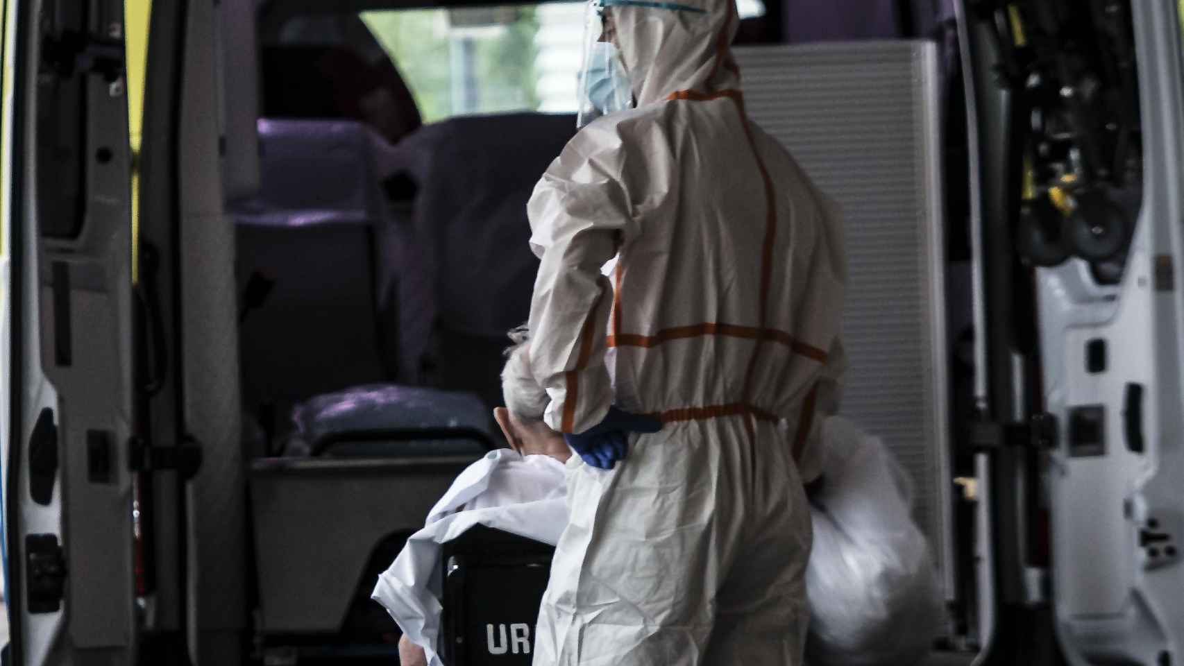 Un trabajador sanitario ayuda a un paciente en la entrada al hospital / EP