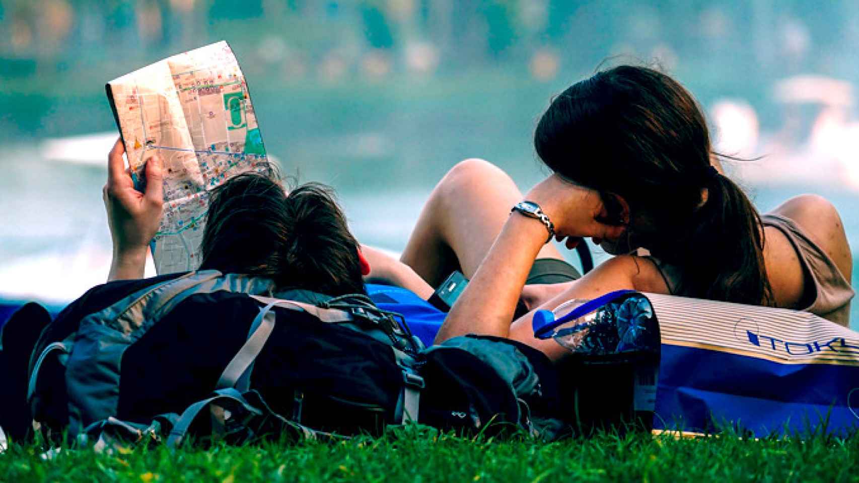 Una pareja de viajeros españoles ojeando un mapa en un parque / PIXABAY