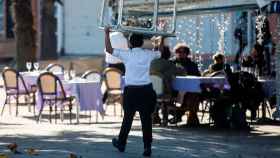 Imagen de un camarero llevando una mesa para montar la terraza / EFE