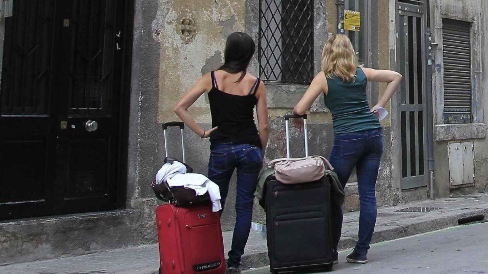 Dos turistas frente a la puerta de un piso turístico en Barcelona / EFE