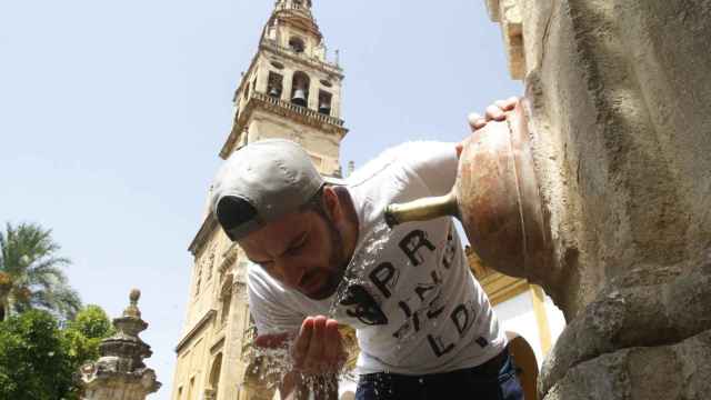 Un hombre se refresca en una fuente pública en Córdoba durante la ola de calor / EFE