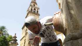 Un hombre se refresca en una fuente pública en Córdoba durante la ola de calor / EFE