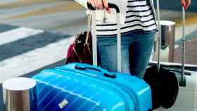Una chica con sus maletas en el aeropuerto / CG