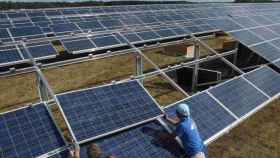 Dos operarios cambian una placa solar de un parque fotovoltaico, en una imagen de archivo / EFE